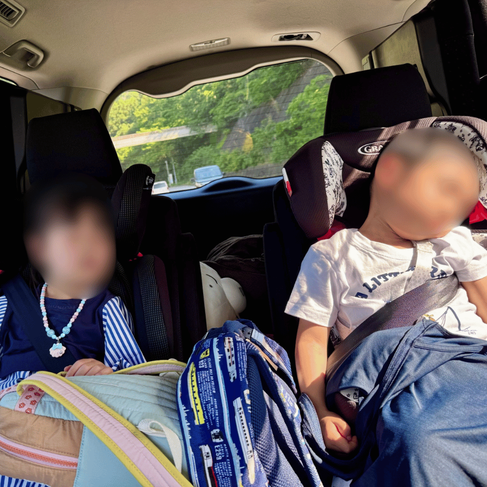 遊び疲れて帰りの車内で眠る子どもたち