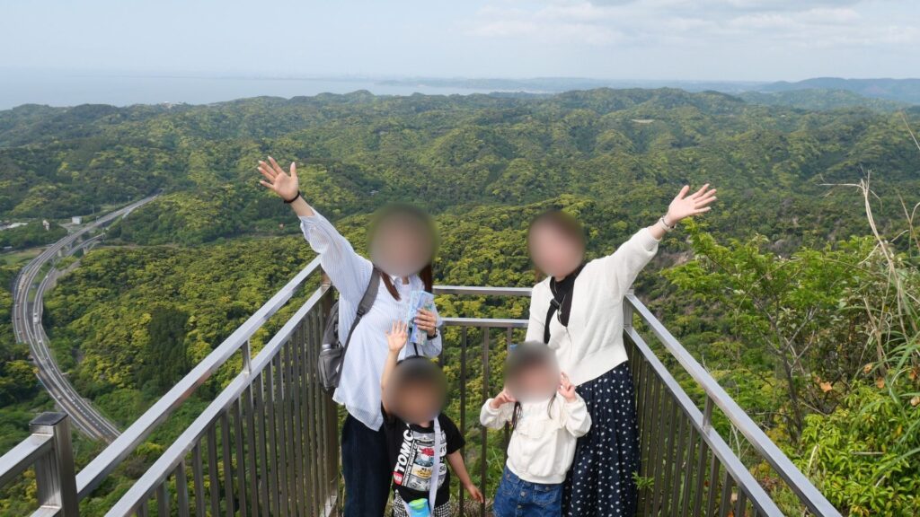鋸山地獄谷の展望台で両手を広げてポーズする家族と子どもたち