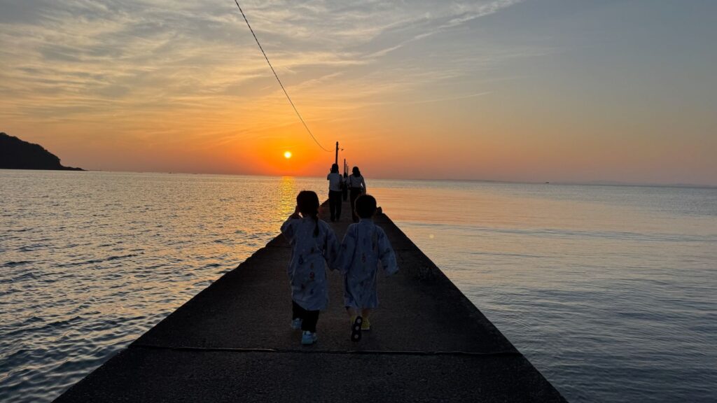 岡本桟橋を歩く浴衣姿の子どもたち、夕日に向かって進む後ろ姿