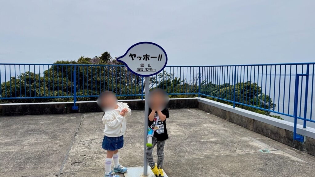 鋸山山頂の「ヤッホー」看板と記念写真を撮る子どもたち