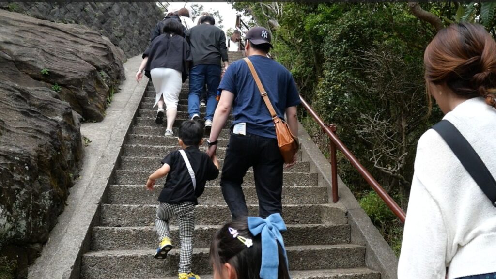 鋸山の急勾配な石段を登る子どもたちと大人たち