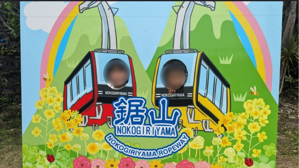 鋸山ロープウェイの顔はめパネルで記念写真を撮る様子