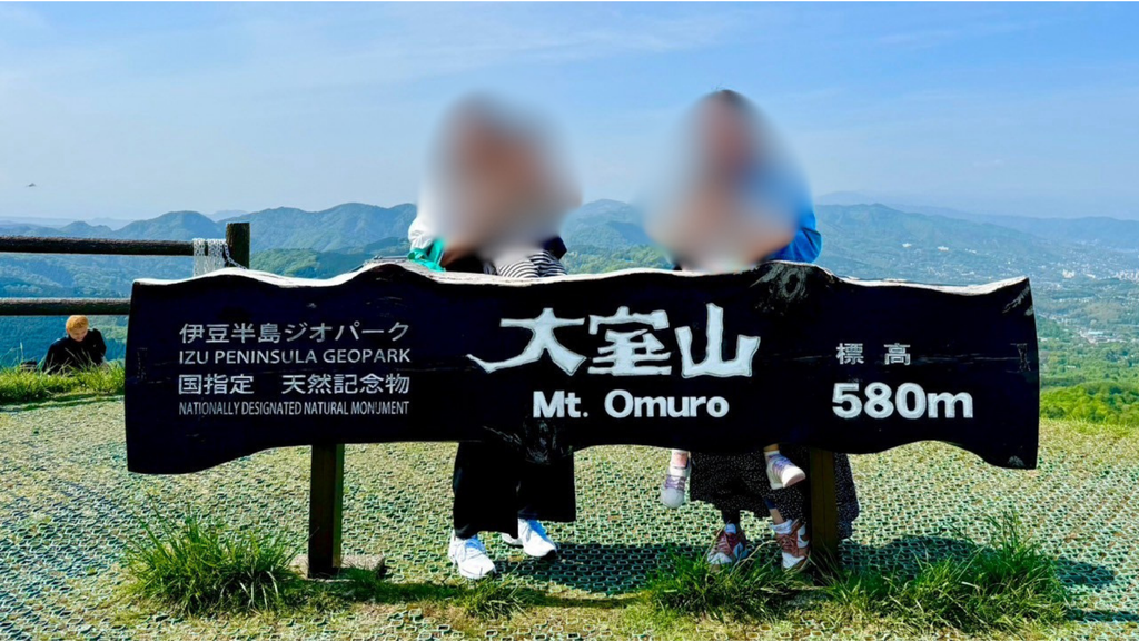 大室山山頂の看板前で記念撮影する子どもたち、標高580m