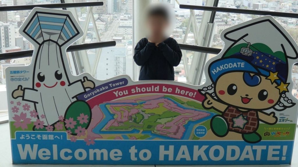 五稜郭タワーのマスコットキャラクターと一緒に記念撮影する子ども