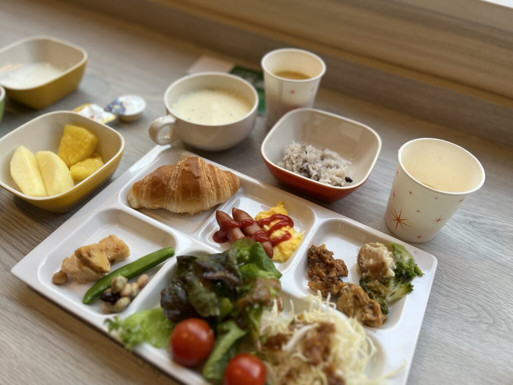 コンフォートホテル函館の朝食ビュッフェ、クロワッサンやパイナップル、雑穀ご飯、スープなどのトレー