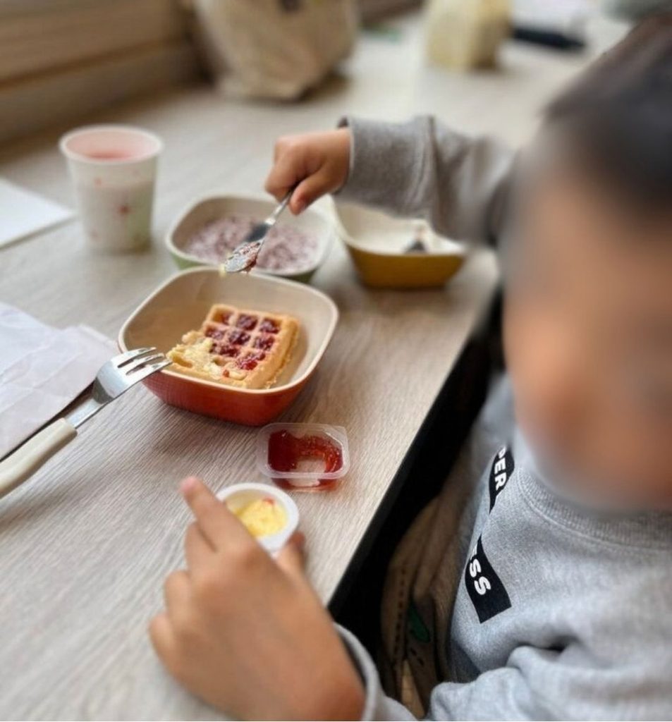 ワッフルにジャムをのせて食べる子ども、朝食の様子